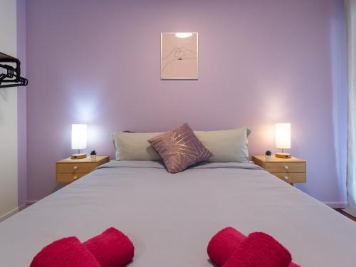 une chambre avec un grand lit blanc avec des oreillers rouges dans l'établissement LE PHENIX - HYPERCENTRE 16 PERSONNES GARAGE GRATUIT WiFi JARDIN BARBECUE PROCHE PARC TETE D'OR, à Villeurbanne