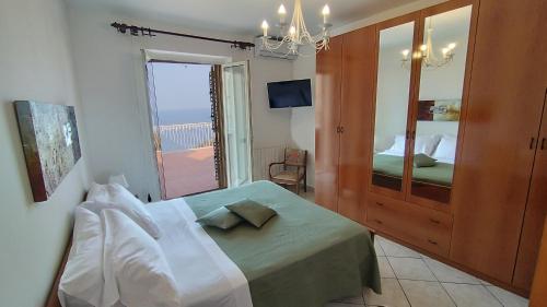 ein Schlafzimmer mit einem Bett und einem großen Fenster in der Unterkunft Casa Carmela Panoramic Center Apartment in Taormina