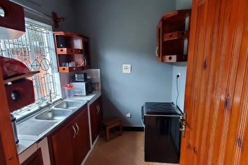 a small kitchen with a sink and a stove at Harukooto Suites in Fort Portal