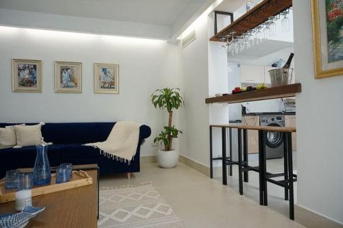 a living room with a blue couch and a kitchen at la villa farniente de sidi bou said in Sidi Bou Saïd