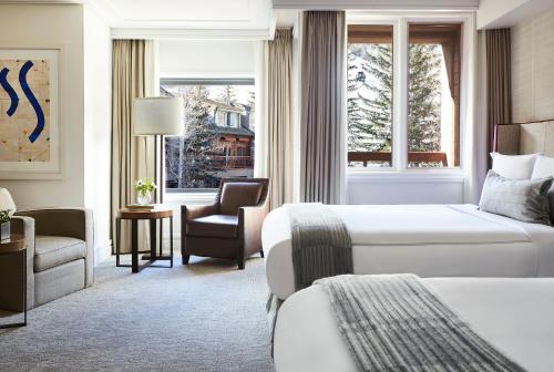 um quarto de hotel com duas camas e uma cadeira em The Little Nell em Aspen