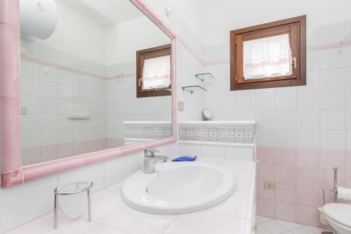 a white bathroom with a sink and a mirror at Trilocale Portovenere Baia II in Cannigione