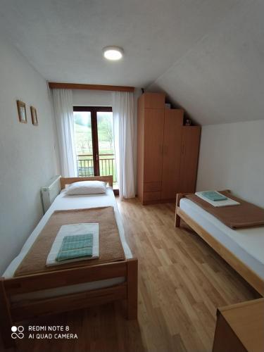 een slaapkamer met 2 bedden en een raam bij Apartment Savkovic in Šipovo