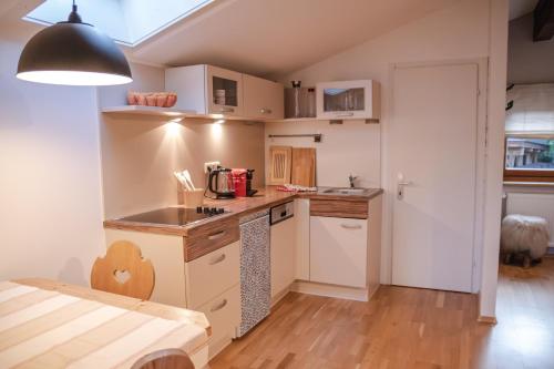 a kitchen with white cabinets and a table in a room at Erika´s Häuschen in Kitzbühel