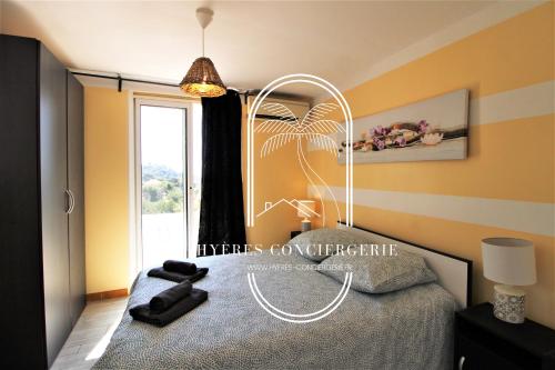 1 dormitorio con cama y ventana en Villa Mont des Oiseaux-Piscine Chauffée Clim Vue Mer Wifi 4 chambres By HC, en Hyères