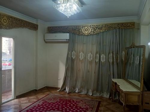 a living room with a curtain and a mirror at 19 Abu Al-Hol Tourist Street, Al-Haram, Nazlet Al-Samman in Cairo