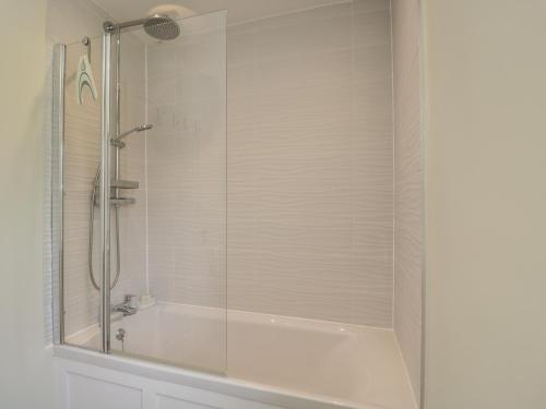 a shower with a glass door and a tub at North Lodge in Malmesbury