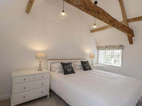 a bedroom with a white bed and a window at The Grooms Flat in Malmesbury