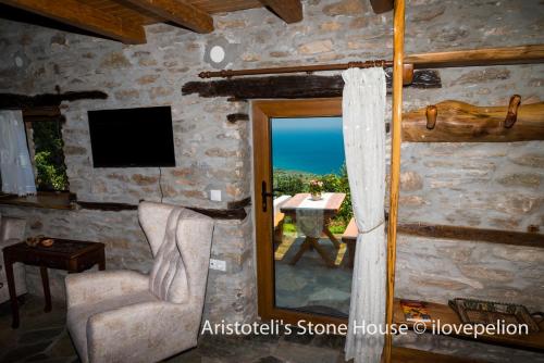 Pokój z widokiem na stół i okno w obiekcie Aristoteli's Stone House w mieście Makrirrákhi