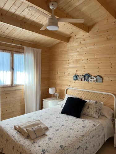 ein Schlafzimmer mit einem Bett in einem Holzzimmer in der Unterkunft La casita del sopapo in Chiclana de la Frontera