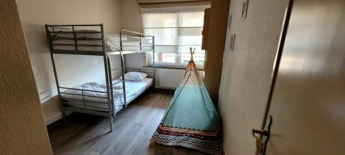a room with two bunk beds and a window at 400m de la mer, calme, lumineux, parking privatif, 3 chambres max 6 personnes in Koksijde