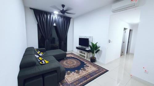 un soggiorno con divano nero e TV di New Modern Condo with Pool at Bangi a Kampong Tangkas