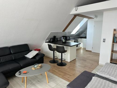 uma sala de estar com um sofá preto e uma mesa em Appartement Sonnenschein em Hüllhorst