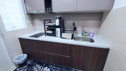 a kitchen with a sink and a microwave at New Modern Condo with Pool at Bangi in Kampong Tangkas