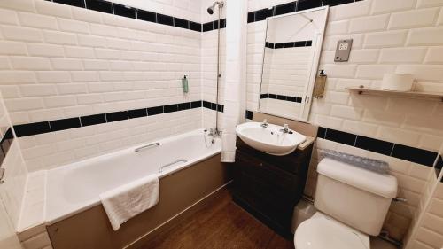 łazienka z umywalką, toaletą i wanną w obiekcie The Brocket Arms Wetherspoon w mieście Wigan