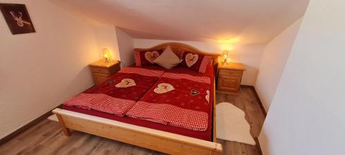 małą sypialnię z łóżkiem z czerwoną kołdrą w obiekcie Haus Bergblick w mieście Mittenwald