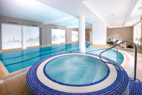 a large swimming pool with a large blue tub at The Caledonian Edinburgh, Curio Collection by Hilton in Edinburgh