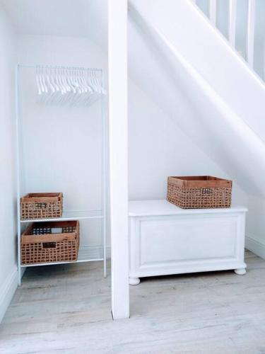 a white staircase with wicker baskets and a white table at TAIL END: Bijoux Broads & Beach Base! Now with TV! in Stalham