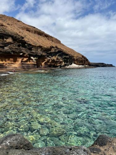 a large body of water next to a rocky beach at La casita in Arona