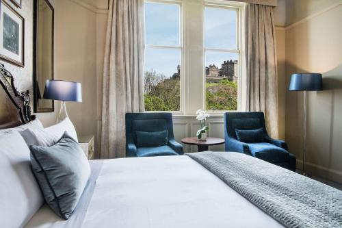 a bedroom with a bed and two chairs and a window at The Caledonian Edinburgh, Curio Collection by Hilton in Edinburgh