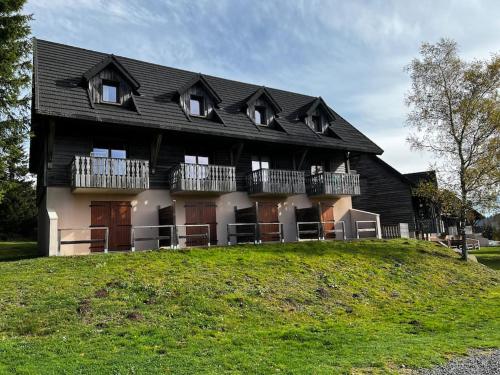 a large house on top of a hill at Charmant logement dans résidence in Super Besse