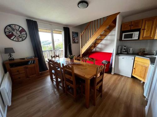 a kitchen and dining room with a table and chairs at Charmant logement dans résidence in Super Besse