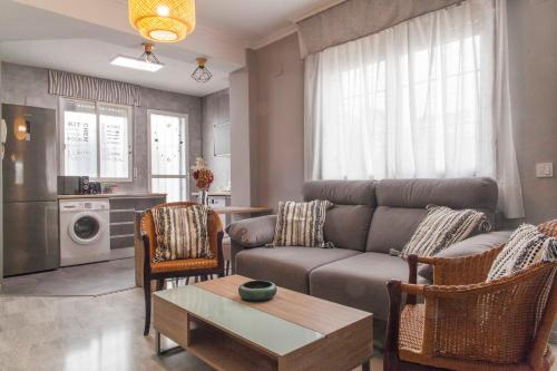 - un salon avec un canapé et une table dans l'établissement Apartamento en el centro totalmente climatizado, parking gratuito, à Cordoue