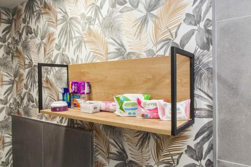 une étagère en bois avec des articles de toilette sur un mur dans l'établissement Apartamento en el centro totalmente climatizado, parking gratuito, à Cordoue