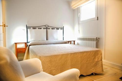 ガラパガルにあるApartamentos individuales con piscinaのベッドと椅子と窓のある寝室