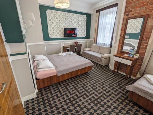 um quarto com uma cama, um sofá e uma janela em Hotel Kamienica em Siedlce