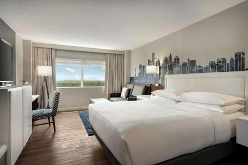 Habitación de hotel con cama blanca grande y sofá en Hilton Meadowlands, en East Rutherford