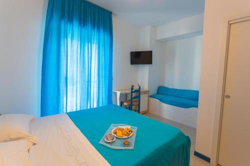 a room with a bed with a tray of fruit on it at ControVento Rooms in Margherita di Savoia