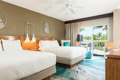 a hotel room with two beds and a balcony at DoubleTree by Hilton Grand Key Resort in Key West