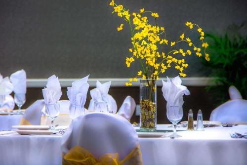 a white table with a vase of yellow flowers on it at DoubleTree by Hilton Grand Key Resort in Key West