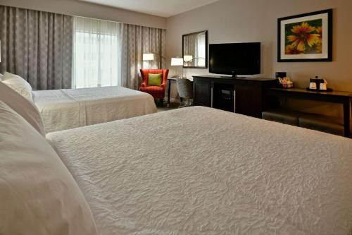 Hampton Inn & Suites Fredericksburg في فريدريكسبيرغ: غرفه فندقيه سريرين وتلفزيون