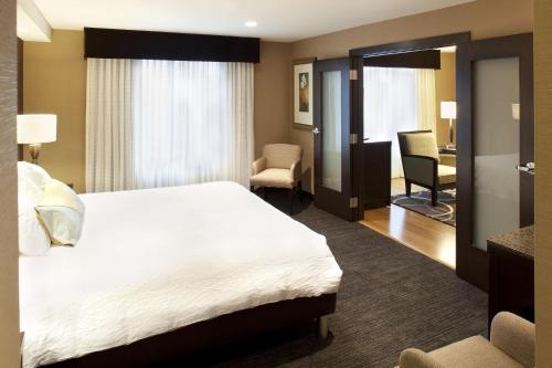 a hotel room with a large bed and a desk at Hilton Garden Inn Sioux Falls South in Sioux Falls