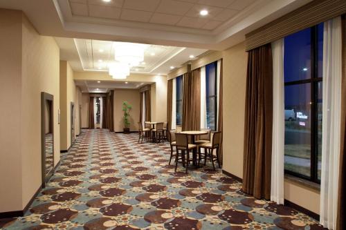 a hallway of a hotel with a table and chairs at Hilton Garden Inn Sioux Falls South in Sioux Falls