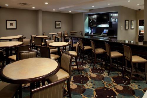 a restaurant with tables and chairs and a bar at Hilton Garden Inn Sioux Falls South in Sioux Falls