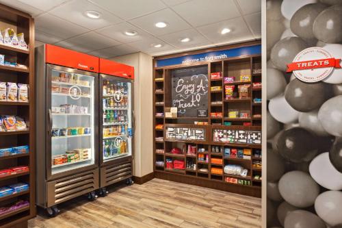 a store aisle with a refrigerator and other products at Hampton Inn by Hilton Fort Smith in Fort Smith