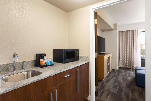 a kitchen with a sink and a television on a counter at Hampton Inn by Hilton Fort Smith in Fort Smith