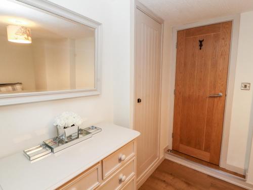 baño con lavabo, espejo y puerta en Tawny Owl, en Carnforth