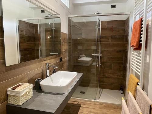 a bathroom with a sink and a glass shower at La dimora delle Rose in Passignano sul Trasimeno