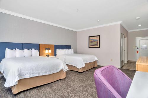a hotel room with two beds and a purple chair at Hampton Inn & Suites Fort Worth-Fossil Creek in Fort Worth