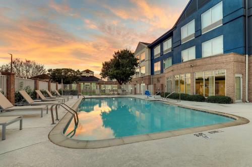 una piscina di fronte a un edificio di Hilton Garden Inn Fort Worth/Fossil Creek a Fort Worth