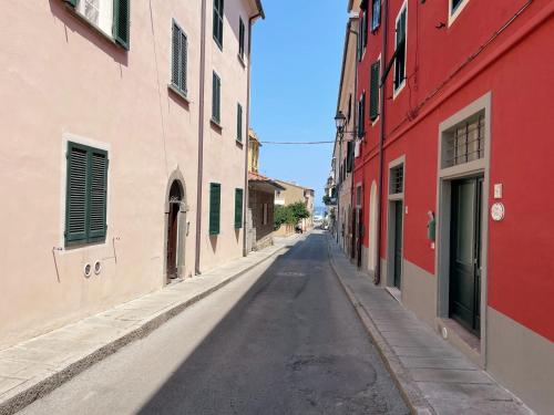 an empty street in an alley with red and white buildings at Casa Costanzo in Marciana Marina