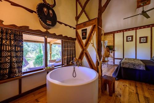 a bathroom with a tub in a room with a bed at Villa Vanille in Boisseron