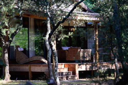 a wooden gazebo with a couch in a garden at Villa Vanille in Boisseron
