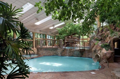 a large swimming pool in a building with trees at The Park Vista - A DoubleTree by Hilton Hotel - Gatlinburg in Gatlinburg