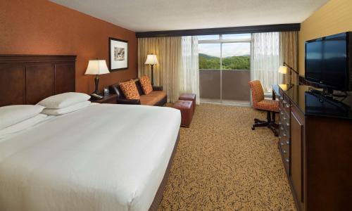 Cette chambre comprend un grand lit et une télévision. dans l'établissement The Park Vista - A DoubleTree by Hilton Hotel - Gatlinburg, à Gatlinburg