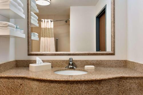 La salle de bains est pourvue d'un lavabo et d'un miroir. dans l'établissement Hampton Inn Gillette, à Gillette